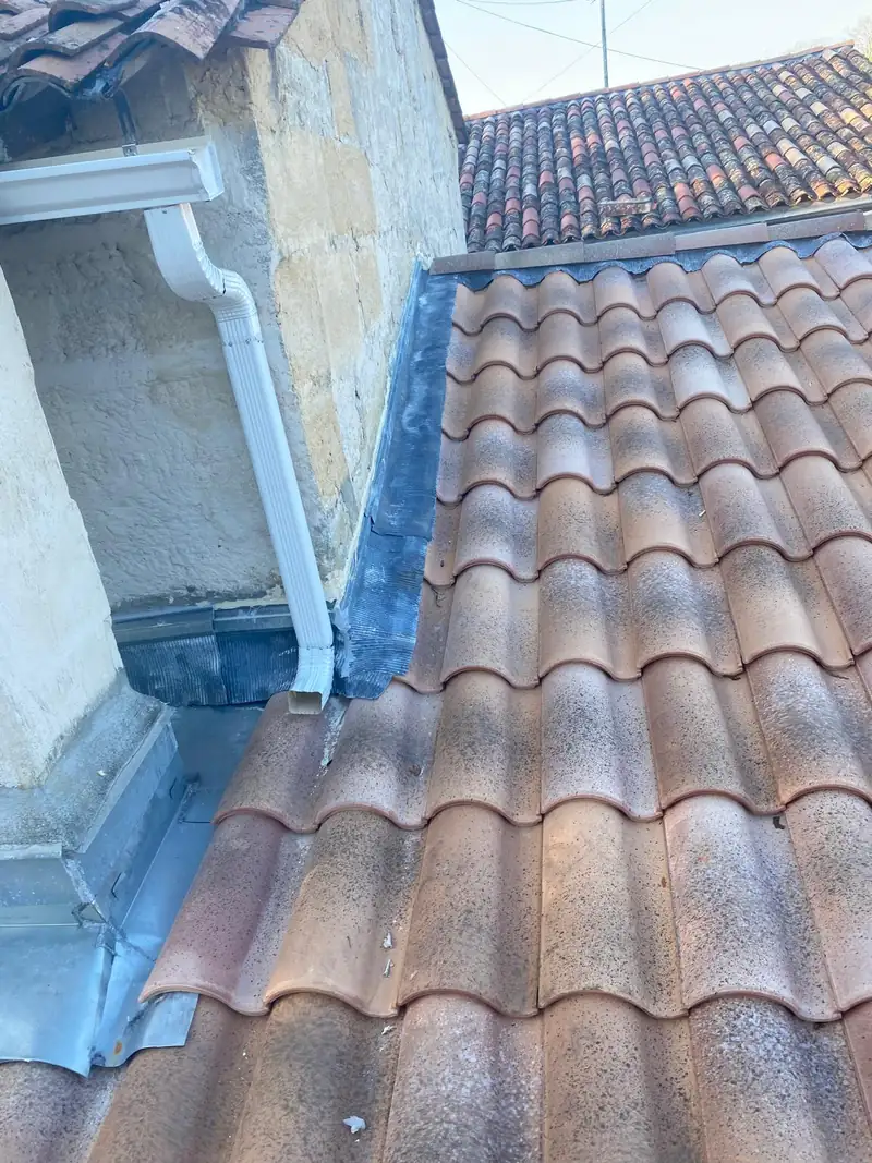 Raccord de zinguerie et gouttière sur une toiture en tuiles